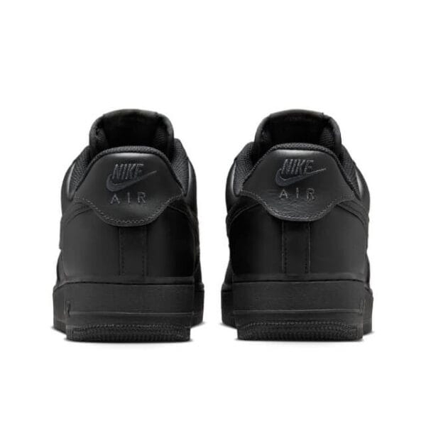 Back view of the Nike Air Force 1 '07 Black sneakers, showcasing the signature heel branding, padded collar, and durable rubber sole.