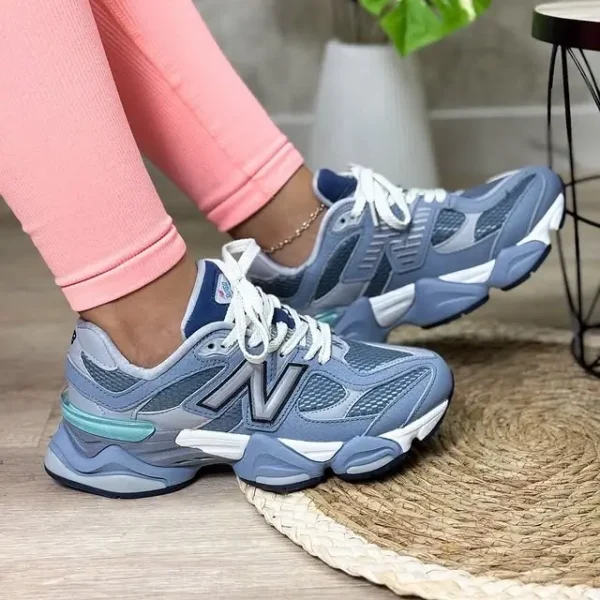 New Balance 9060 Moon Daze styled on a woman wearing pink long tights, showcasing the sneaker’s grey mesh base, off-white suede overlays, and chunky ABZORB-cushioned sole