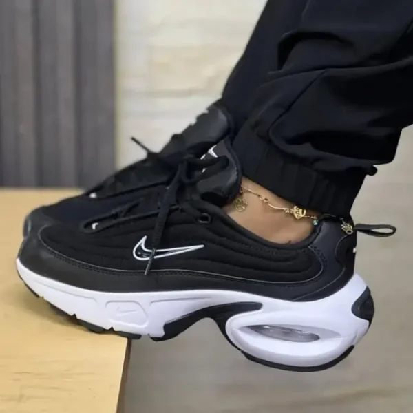 “Nike Air Max Portal Black/White worn by a woman in black pants, showcasing the black mesh upper, white sculpted midsole, visible Air Max heel unit, and layered synthetic panelling