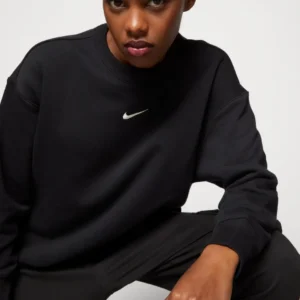 Black Nike crewneck sweater featuring a small white Swoosh embroidered just below the collar, laid flat on a neutral background