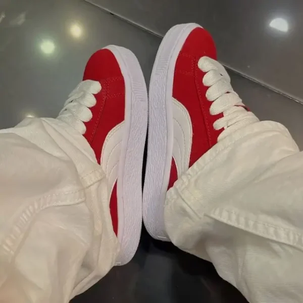 Puma Suede XL Red styled on a lady wearing beige trousers, showcasing the sneaker’s premium red suede, chunky rubber sole, and classic Puma branding