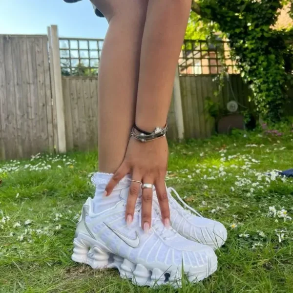 Nike Shox TL ‘White’ worn by a woman with white crew socks, showcasing white mesh upper, tonal TPU overlays, full-length Shox columns, and sculpted heel design